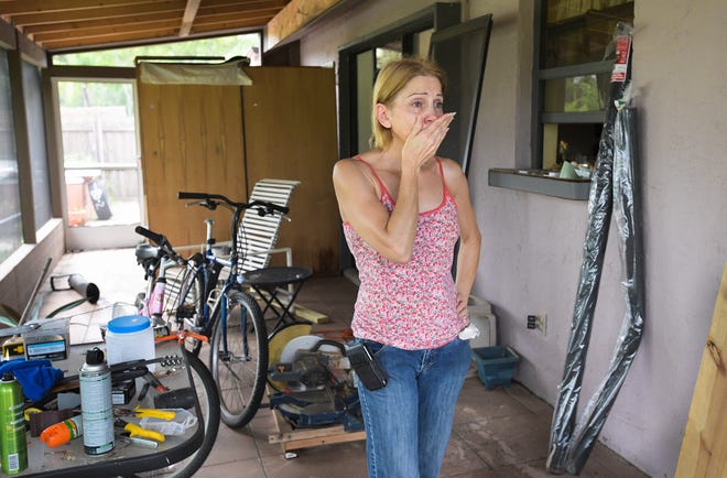 Karen Stennes is overcome with emotion as she sorts through her belongings on Tuesday. Stennes' home in Centre Lake was flooded over the weekend. [Herald-Tribune staff photo / Dan Wagner]
