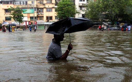 A man wades through a waterlogged street following heavy rains in Mumbai, India, Tuesday, Aug. 29, 2017. Heavy rains Tuesday brought Mumbai to a halt flooding vast areas of the city. (AP Photo/Rajanish Kakade)