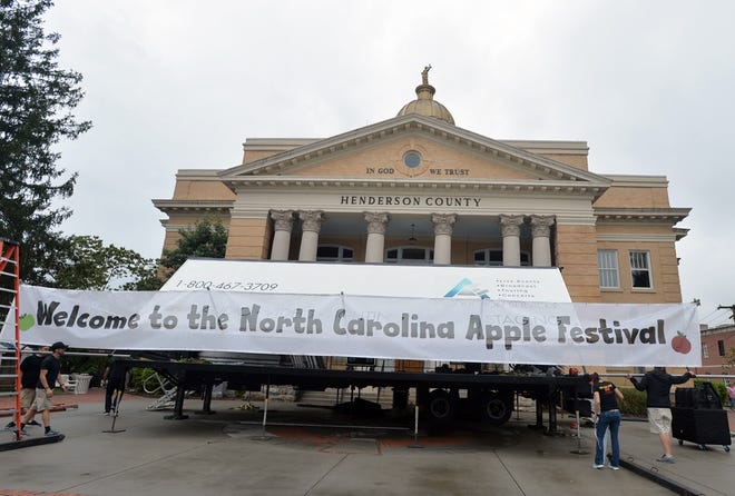Workers set up the main stage in front of the Historic Courthouse on Main Street in Hendersonville Thursday as they prepare for the annual North Carolina Apple Festival. The festivities kick off with the Kiwanis Pancake Breakfast at 7 a.m., followed by the opening ceremeony and naming of the Apple Farmer of the Year at 10 a.m. Live entertainment, the street fair, an apple recipe contest, apple taste testing, kiddie carnival and more also begin at 10 a.m. The National Weather Service is calling for rain and thunderstorms throughout the day Friday, with a high of 73. Partly cloudy or sunny skies with no rain are expected Saturday, Sunday and Monday. For more information about the festival, visit www.ncapplefestival.org. [PATRICK SULLIVAN/TIMES-NEWS]