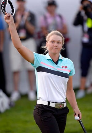 Brooke Henderson, of Canada, salutes the crowd after finishing up on the 18th hole during the final round of the Canadian Pacific Women's Open golf tournament in Ottawa, Ontario, Sunday, Aug. 27, 2017. (Adrian Wyld/The Canadian Press via AP)