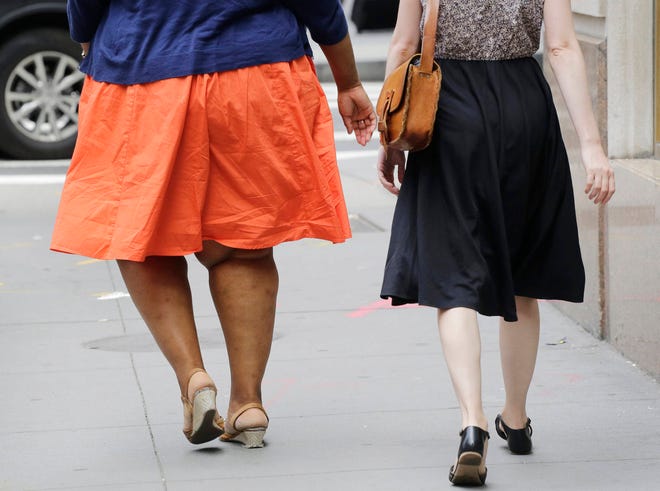 In this Monday, July 13, 2015 file photo, an obese woman, left, walks in New York. The overall obesity rate in Kansas declined to 31.2 percent from 34.2 percent in 2015, while none of the other 49 states or District of Columbia moved the dial in the positive direction. (AP file Photo/Mark Lennihan)