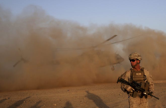 A U.S. Marine takes part during a training session for Afghan army commandos in Shorab military camp in Helmand province, Afghanistan. The Pentagon admitted Wednesday there are more American troops in the country than had previously been announced. [Massoud Hossaini/The Associated Press file]
