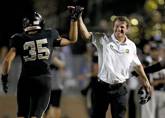 Buchholz coach Mark Whittemore celebrates with Kyle Brasfiield after a blocked punt for a safety against Vanguard in 2015 at Citizens Field.