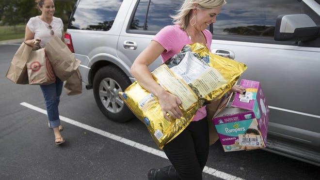 Natalie Kifer, right, helps Krista Harmon, left, carry items donated to the flood victims of Hurricane Harvey. Ricardo B. Brazziell / AMERICAN-STATESMAN