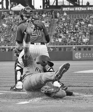 Arizona Diamondbacks' David Peralta (6) slides safe into home plate against Colorado Rockies catcher Jonathan Lucroy (21) during the first inning of a baseball game Friday, Sept. 1, 2017, in Denver. (AP Photo/Jack Dempsey)