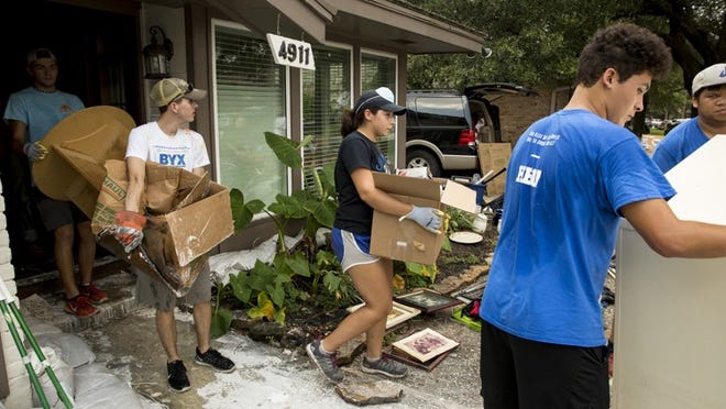 Volunteers from Houston Baptist University clean out a flooded home in Houston a week after Hurricane Harvey hit. Ilana Panich-Linsman / THE NEW YORK TIMES