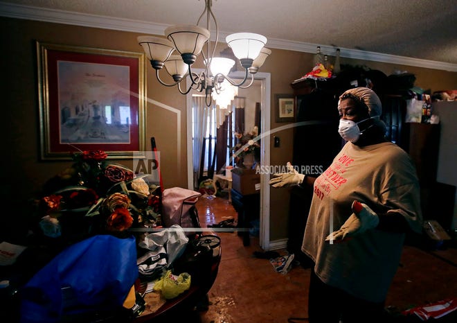 Lois Rose looks over belongings while salvaging items from her flood-damaged house Thursday in Houston. The city continues to recover from record flooding caused by Hurricane Harvey.