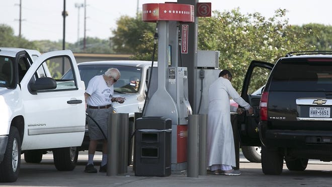 People endure long lines Friday as they wait to fill their vehicles at aH-E-B gas station at North Lamar Boulevard and Rundberg Lane in North Austin.
