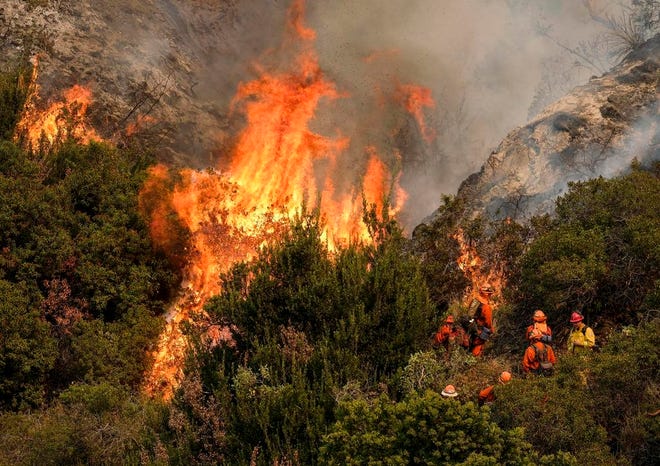 A crew with California Department of Forestry and Fire Protection (Cal Fire) battles a brushfire on the hillside in Burbank, Calif., Saturday, Sept. 2, 2017. Several hundred firefighters worked to contain a blaze that chewed through brush-covered mountains, prompting evacuation orders for homes in Los Angeles, Burbank and Glendale.