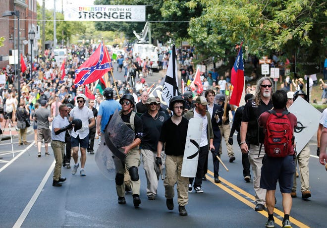 Alt Right demonstrators walk through town after their rally was declared illegal near Lee Park in Charlottesville, Va., Saturday, Aug. 12, 2017. (AP Photo/Steve Helber)