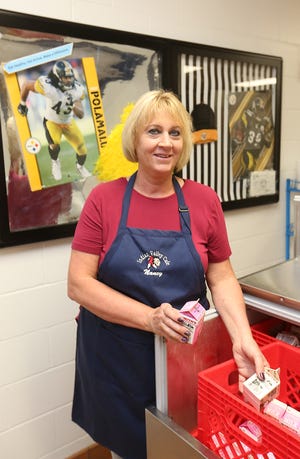 Nancy Lahmers, the cook at Midvale Elementary straightens up the milk refrigerator recently in the lunch room. (TimesReporter.com / Jim Cummings)