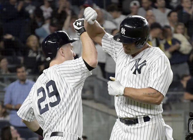 Yankees designated hitter Matt Holliday (right) celebrates with Todd Frazier after hitting a home run during the fourth inning of New York's 9-2 win over the Red Sox on Sunday night.
