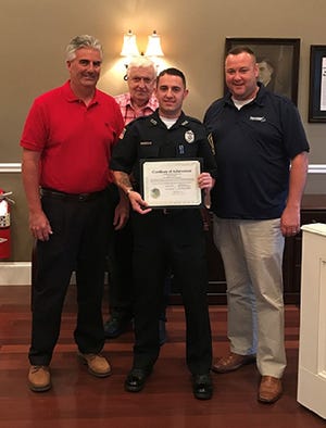 Officer Casey Surprenant displays his citation. Looking on are selectmen Kevin J. Sheehan (left), chairman Daniel R. Lee (right) and Richard B. McGaughey. (Photo courtesy/Eryc Courmac)