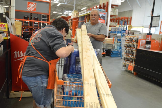 Home Depot cashier Linda Marek, of Leesburg, rings up storm supplies purchased by William Noel, of Leesburg, on Tuesday in Leesburg in preparation for Hurricane Irma's potential impact on Lake County. [Whitney Lehnecker / Daily Commercial]