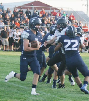 A-W’s Zac VanOpdorp looks to turn the corner during the Titan’s loss to Elmwood-Brimfield in week two. VanOpdorp had a pair of touchdowns in the game including a 75-yard kick return.