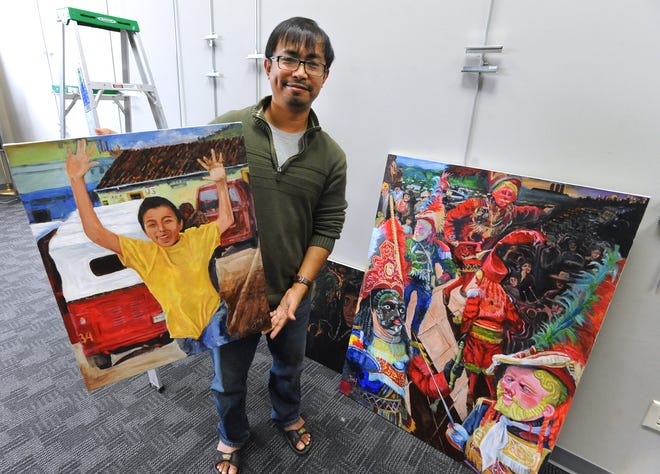 TIMES-REPORTER PAT BURK

Jogendro Kshetrimayum shows a couple of his paintings of Nebaj, Guatemala, which will be on display throughout September, which is National Hispanic Heritage Month, at the Dover Public Library.