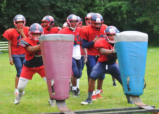 Members of the Willingboro High School football team run a drill during a practice at the high school on Friday, August 11, 2017.