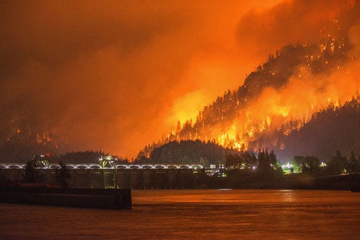 This photo provided by KATU-TV shows a wildfire as seen from near Stevenson Wash., across the Columbia River, burning in the Columbia River Gorge above the Bonneville Dam near Cascade Locks, Ore.