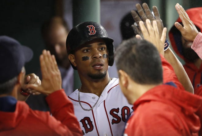 Xander Bogaerts is greeted in the dugout after scoring against the Toronto Blue Jays during the fourth inning of the Red Sox's 6-1 win Wednesday over the Toronto Blue Jays. [AP Photo/Winslow Townson]