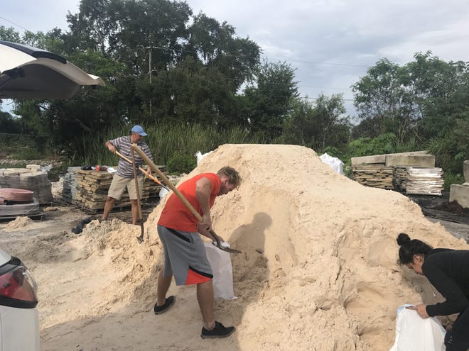 People fill up sandbags Wednesday at Big Earth Landscape in Sarasota County. [HERALD-TRIBUNE STAFF PHOTO / ASHLEY DEETS]