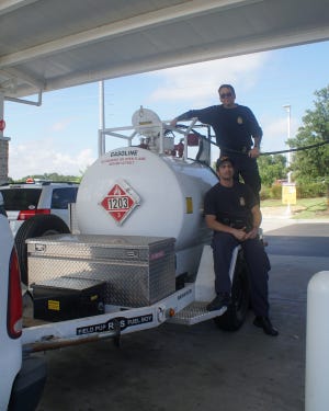 Jay Cee Taylor, top, and Wesley Zamora gas up Thursday at the Clermont Wawa with enough gas to power the entire Customs and Border Patrol fleet in Miami. [LINDA CHARLTON / CORRESPONDENT]