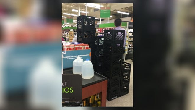 Plastic crates stand empty this morning in the Palm Beach Publix, where workers distributed water by rationing it at two gallon jugs per customer. Darrell Hofheinz / Daily News