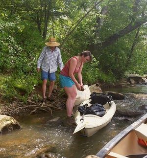 Sarah Spencer and David Caldwell pick up trash along the river during a sweep in 2016, just before Spencer was killed in a car wreck. [Special to The Star]