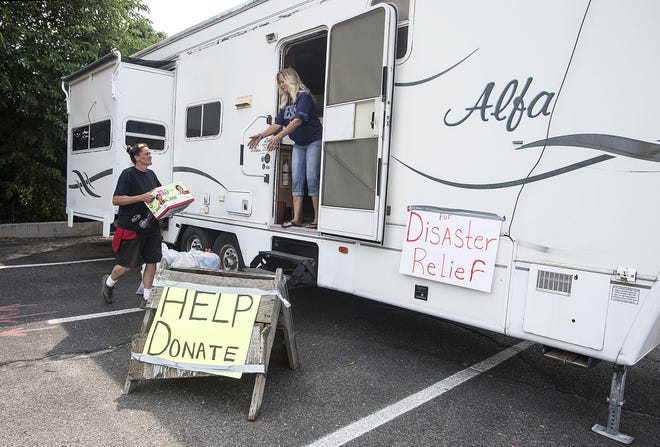 CHIEFTAIN PHOTO/JOHN JAQUES Wendy Samora (left) and Bonnie Williams load items into a trailer that they are collecting items to take to Houston.