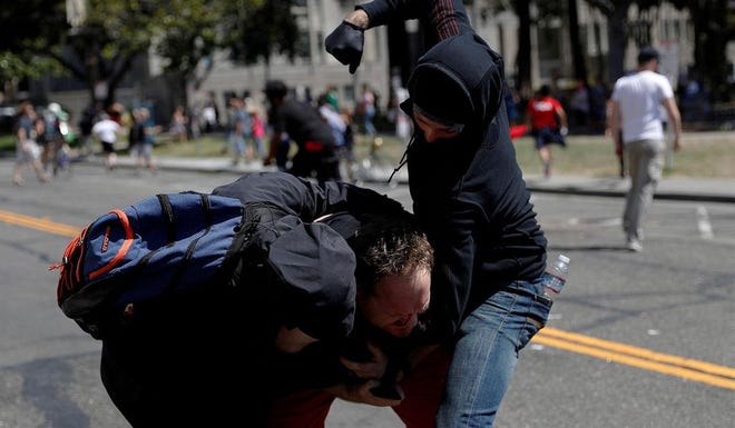 Masked demonstrators beat a cameraman during a rally in Berkeley, Calif., Aug. 28, 2017.
