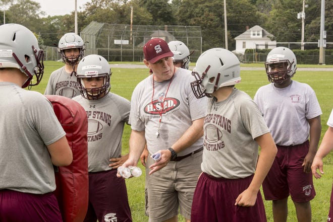 Bishop Stang head coach Dennis Golden works with the offensive line during practice. [RYAN FEENEY/STANDARD-TIMES SPECIAL/SCMG]