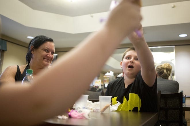 Dawn Robertson watches her sons Draven Crawford, 10, and Dillan Crawford, 6, play with McDonald's toys provided by Costa Enterprises at La Quinta Inns and Suites on Saturday. David Costa, owner of Costa Family McDonald's, said his restaurants wanted to help, so they provided free meals to evacuees staying at the hotel. [JOSHUA BOUCHER/THE NEWS HERALD]