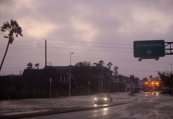 A car drives through a flooded street after Hurricane Irma passed through Naples, Fla., Sunday, Sept. 10, 2017. (AP Photo/David Goldman)