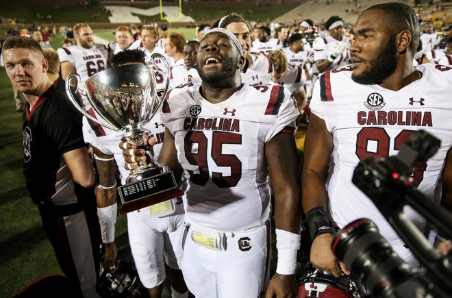 South Carolina defensive lineman Dante Sawyer (95) celebrates with the Mayor's Cup after the Gamecocks defeated Missouri 31-13 on Saturday on Faurot Field. [Timothy Tai/Tribune]