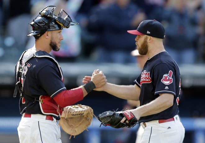 Cleveland relief pitcher Cody Allen, right, and catcher Yan Gomes celebrate after the Indians defeated the Baltimore Orioles 4-2 on Saturday. The Indians have won 17 straight. [Tony Dejak/The Associated Press]