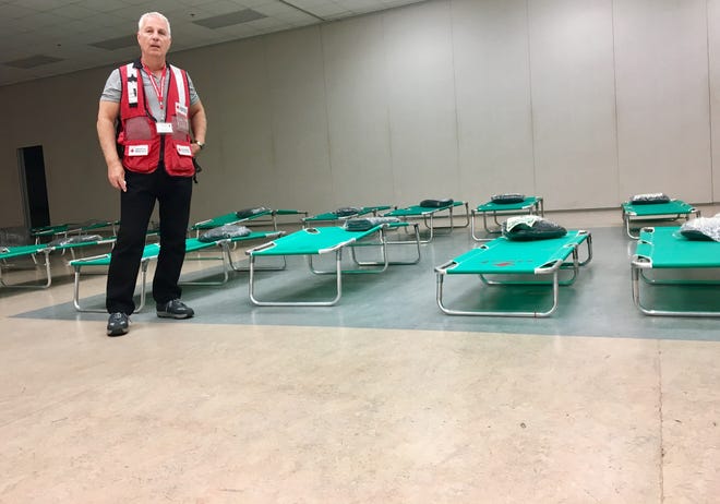 Red Cross shelter manager Don Prelich talks about the services the Gaston County shelter is offering in front of some of the cots set up for evacuees from Florida and South Carolina on Sunday, Sept. 10, 2017. No one has used the shelter yet, but Prelich is hoping it will be an alternative for those who can't afford hotel rooms. [Alyssa Pressler/The Gaston Gazette]