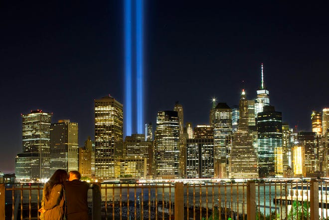 A couple embraces on the Brooklyn Promenade as the Tribute in Light rises above the lower Manhattan skyline Sunday, Sept. 10, 2017, in New York. The two blue pillars of light provide a visual reminder of how the Twin Towers, destroyed in the terrorist attacks of Sept. 11, 2001, once stood above the city skyline. (AP Photo/Mark Lennihan)