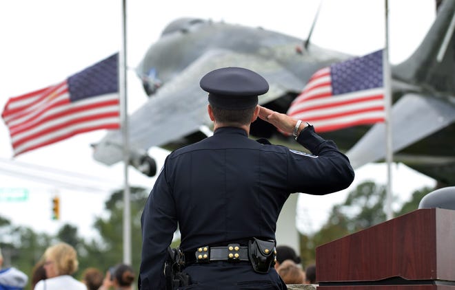 Havelock Police Chief David Magnusson leads a salute to the flag during the National Athem to begin the annual 9/11 ceremony on Monday morning. [CHARLIE HALL / SUN JOURNAL]
