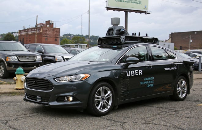 A self-driving Uber car heads down River Road on Pittsburgh’s Northside.