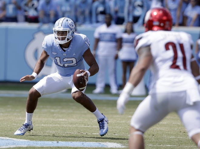North Carolina quarterback Chazz Surratt (12) looks to pass as Louisville's London Iakopo (21) applies pressure during the first half of an NCAA college football game in Chapel Hill, N.C., Saturday, Sept. 9, 2017. Louisville won 47-35. (AP Photo/Gerry Broome)