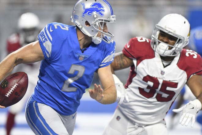 Detroit Lions punter Kasey Redfern (2) runs the ball out of the end zone as Arizona Cardinals running back Elijhaa Penny (35) pursues during the first half of an NFL football game in Detroit, Sunday, Sept. 10, 2017. (AP Photo/Jose Juarez)