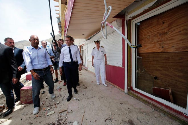 France's President Emmanuel Macron looks at damaged houses destroyed by Irma during his visit in the French Caribbean islands of St. Martin on Tuesday. Macron is in the French-Dutch island of St. Martin, where 10 people were killed on the French side and four on the Dutch.