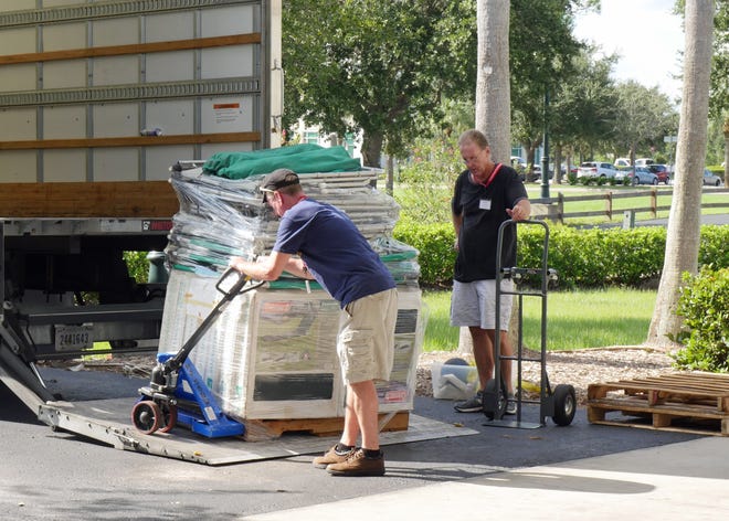 American Red Cross volunteers Mike Reznick, left and Kevin Fitzgerald, along with Jerry Weincrowski (not pictured) unloaded more than 150 cots at the at the George Mullen Activity Center, 4956 City Center Blvd., North Port, which was scheduled to open Tuesday night for residents along the Myakkahatchee Creek to use as shelter if rising waters makes their homes inaccessible. [HERALD-TRIBUNE STAFF PHOTO / EARLE KIMEL]