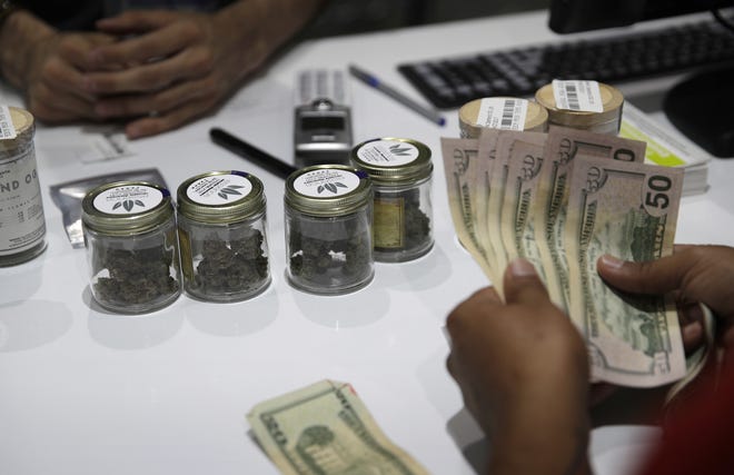 A person buys marijuana at the Essence cannabis dispensary in Las Vegas. Lynn Haven officials on Monday approved drafting an ordinance allowing dispensaries in the city. [FILE PHOTO]