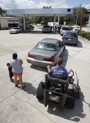Waiting for gasoline was not just for those in vehicles. Josie Zamarripa, from left, with her grandson, Julian Blas, 2, and Rod DuBose from Bulldog Lawn Care wait in line at Barnett's in Fort Meade on Tuesday. [PIERRE DUCHARME/THE LEDGER]