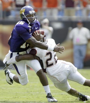 East Carolina quarterback Patrick Pinkney, left, is tackled by Virginia Tech cornerback Stephan Virgil during the first half of a college football game at Bank of America Stadium on Aug. 30, 2008 in Charlotte, N.C. (AP Photo/Nell Redmond)
