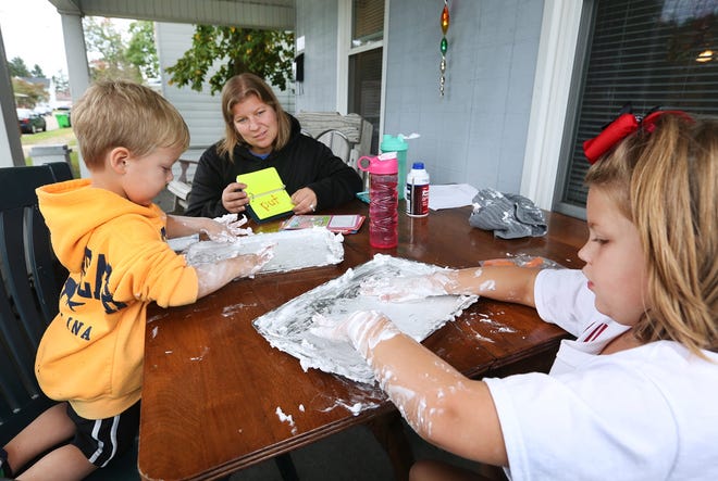 TIMES-REPORTER PAT BURK

Kristen Parker helps her daughter Allie, 6, learn her spelling words, and her son Gavyn, 3, spell his name, using pans full of shaving cream Tuesday evening on the front porch of their Dover home.