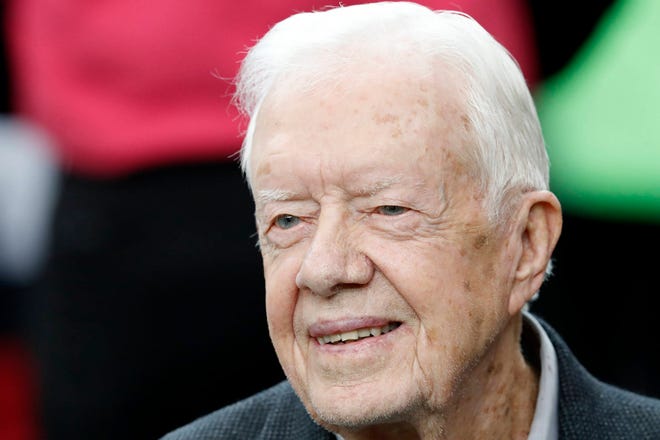 In this Oct. 23, 2016 file photo, former President Jimmy Carter sits on the Atlanta Falcons bench before the first half of an NFL football game between the Atlanta Falcons and the San Diego Chargers, in Atlanta. Speaking to Georgia college students, the 39th president Carter expressed optimism Wednesday, Sept. 13, 2017, that Trump might break a legislative logjam with his controversial six-month deadline for Congress to address the immigration status of 800,000-plus U.S. residents who were brought to the country illegally as children. (AP Photo/John Bazemore, File)