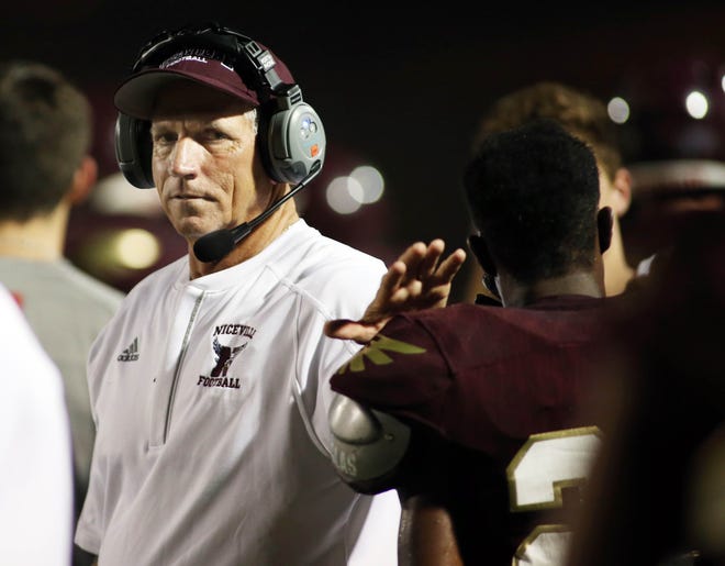 Head coach John Hicks pats a player on the pads as Niceville hosted Pace in the Kickoff Classic Friday evening. [MICHAEL SNYDER/DAILY NEWS] .