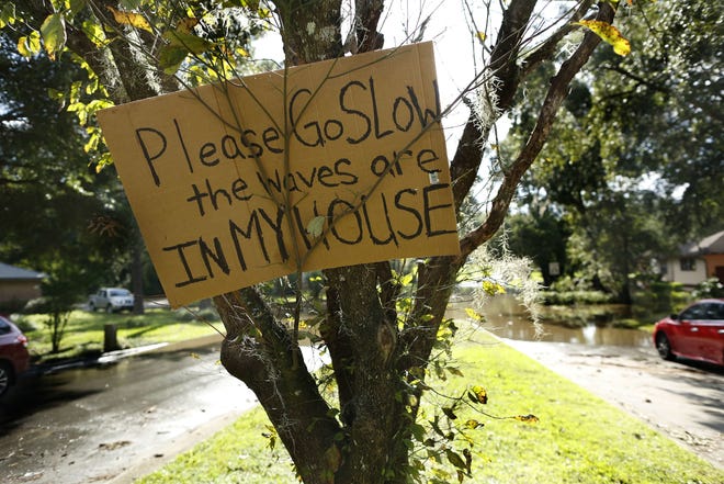 A sign the Pena family put in a tree at the entrance of the Hills of Santa Fe neighborhood, in Gainesville, Tuesday Sept. 12, 2017. During Hurricane Irma water from the Meadowbrook Golf Course rushed over a hill behind the Pena's home and flooded the home with about six feet of water. After Hurricane Irma hit Gainesville, flooded homes and streets seem to be some of the biggest problems residents are dealing with. (Brad McClenny/The Gainsville Sun via AP)