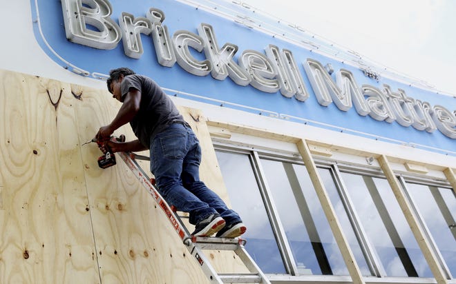 Erson Perez installs wood shutters on a business in the Little Havana neighborhood of Miami, Friday, Sept. 8, 2017. Hurricane Irma weakened slightly Friday but remained a dangerous and deadly hurricane taking direct aim at Florida, threatening to march along the peninsula's spine and deliver a blow the state hasn't seen in more than a decade. (AP Photo/Marta Lavandier)